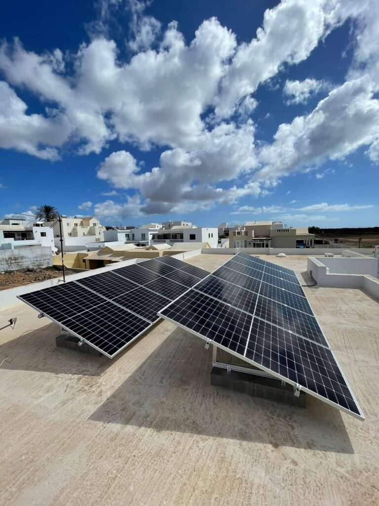 Paneles solares fotovoltaicos sobre azotea de vivienda moderna para energía solar en Canarias